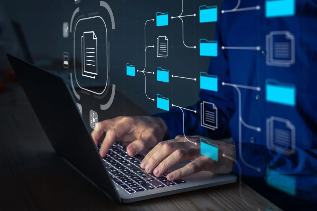Professional using a laptop with a digital file-management interface